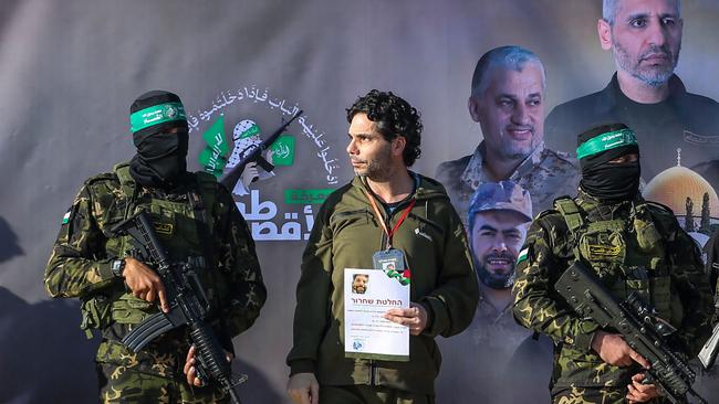 Palestinian militant group Hamas fighters escort Israeli-French hostage Ofer Kalderon on a stage before handing him over to a Red Cross team in Khan Yunis.