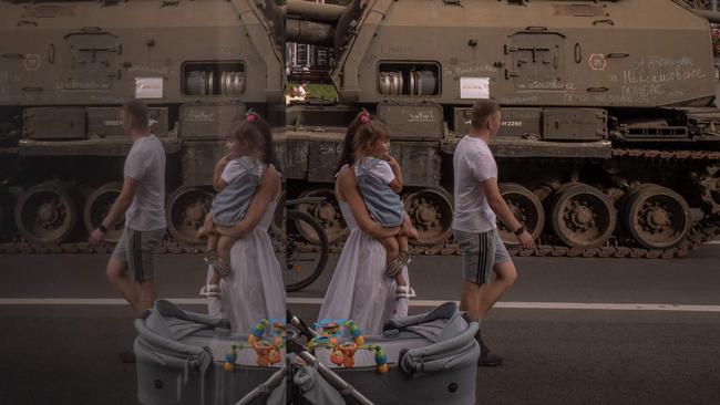 A family walks past destroyed Russian armoured military vehicles on display in Khreshchatyk on Saturday. Picture: AFP