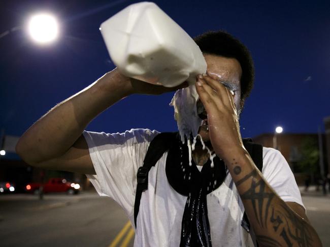 Protesters wash out tear gas with milk as violence breaks out following a peaceful protest in support of George Floyd in Des Moines, Iowa. Picture: Brian Powers/The Des Moines Register via AP