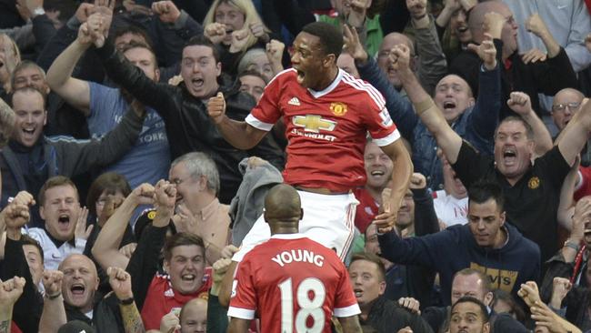 Manchester United's French striker Anthony Martial (top) celebrates scoring their third goal with Manchester United's English midfielder Ashley Young (bottom) during the English Premier League football match between Manchester United and Liverpool at Old Trafford in Manchester, north west England, on September 12, 2015. AFP PHOTO / OLI SCARFF RESTRICTED TO EDITORIAL USE. No use with unauthorized audio, video, data, fixture lists, club/league logos or 'live' services. Online in-match use limited to 75 images, no video emulation. No use in betting, games or single club/league/player publications.