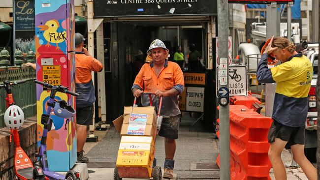 Workers leave the Probuild worksite on 443 Queens Street. Picture: Zak Simmonds