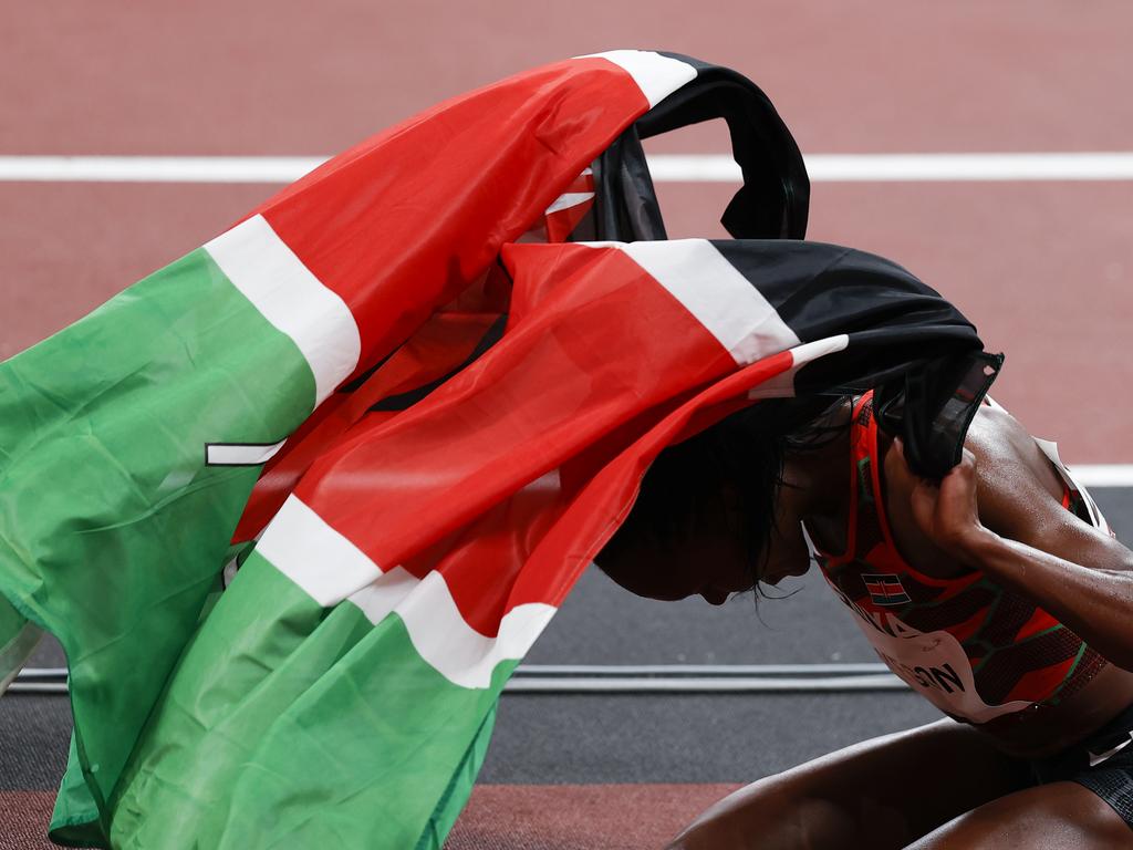 Faith Kipyegon covers herself in the Kenyan flag after covering herself in Olympic glory. (Photo by Fred Lee/Getty Images)