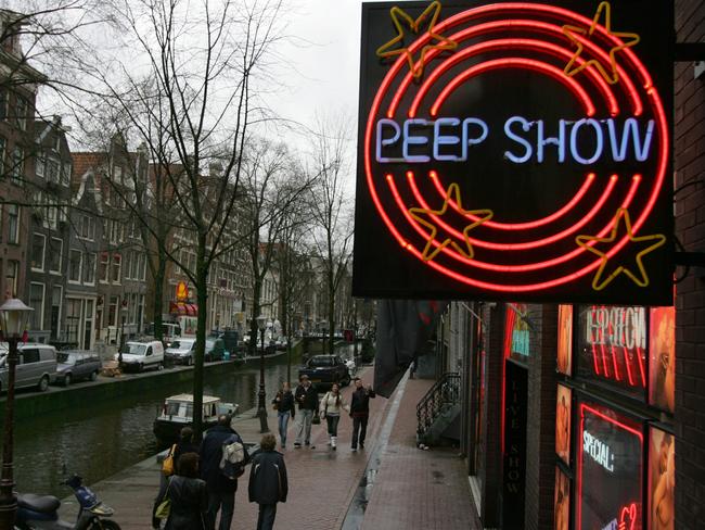 A neon sign advertising a peep show flashes in the red light district in Amsterdam, Netherlands. An Amsterdam judge has ruled that peep shows, where sex workers performing strip shows and explicit acts can be watched from booths, are a form of theater and club owners are entitled to a hefty tax break. "Admitting customers to peep shows is equivalent to admitting them to a theater performance", an Amsterdam appeals court judge wrote in a ruling. Cultural performances are taxed in a lower, 6 percent, bracket. (AP Photo/Peter Dejong)