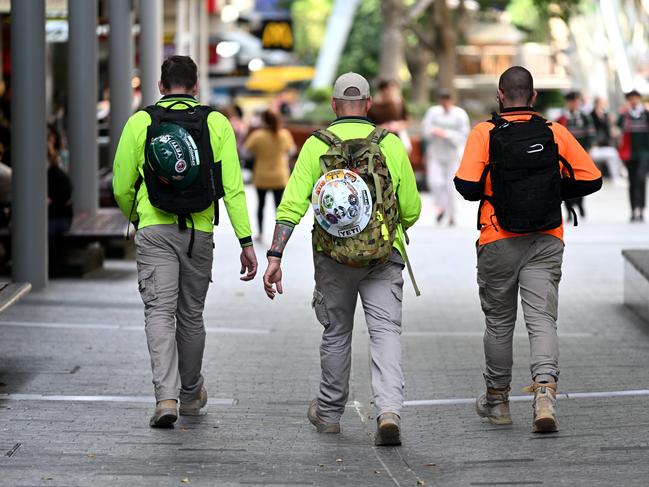 BRISBANE, AUSTRALIA - NewsWire Photos - AUGUST 31, 2022.Construction workers walk through Brisbane's CBD at the end of their work day. Queensland Education Minister Grace Grace has announced a new $10 million pilot program to boost the number of industrial technology and design (ITD) teachers, which will support tradies to become teachers in state schools.Picture: NCA NewsWire / Dan Peled