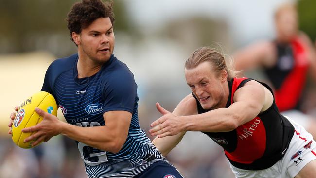 Brandan Parfitt ducks away from Essendon defender Mason Redman during pre-season.