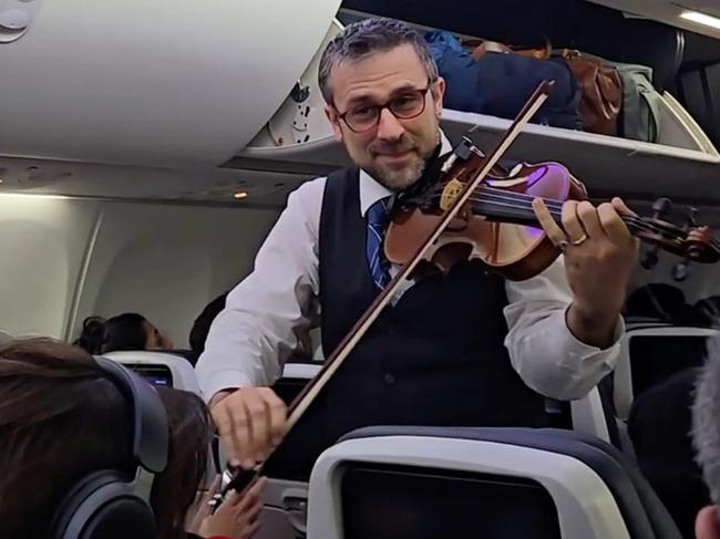 A flight attendant for United Airlines cheerfully played the violin after touching down in California - but his behavior fell flat for some critics.