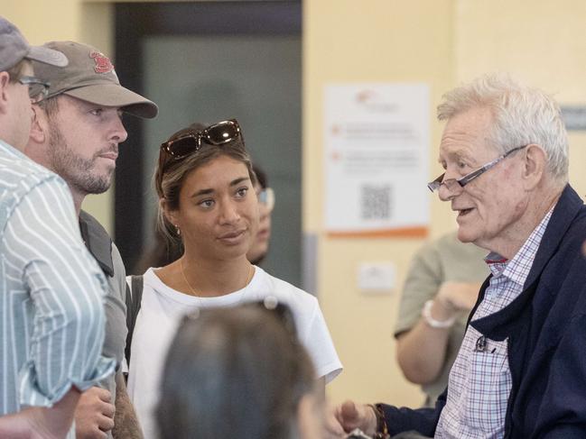 Rolfe and his girlfriend speaking with Michael Abbott KC after arriving in Alice Springs on Sunday evening. Picture: Liam Mendes