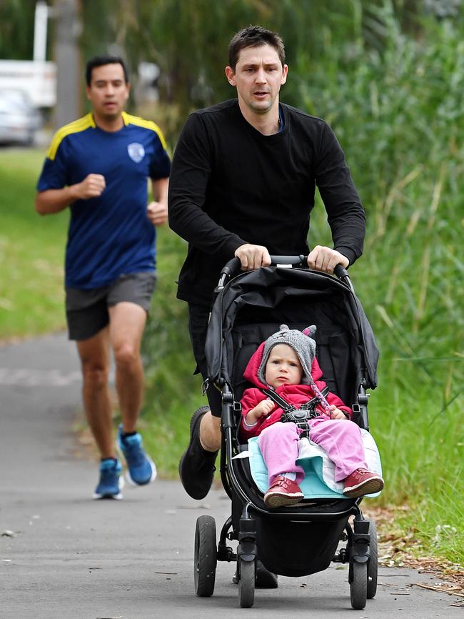 Glynn Foot with his daughter running near the River Torrens. Picture: Tom Huntley