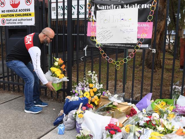 A man places flowers. Picture: Dean Lewins