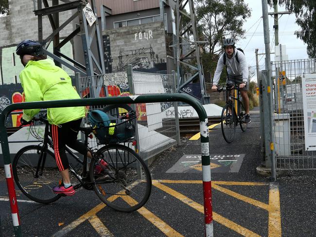 Two cyclists navigate the narrow rail crossing. Picture: Hamish Blair