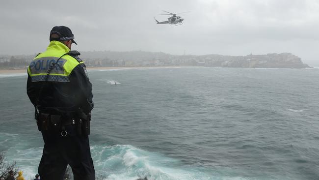 The Westpac helicopter, police and Bondi lifeguards search the water off Icebergs after a report of a missing swimmer .Picture John Grainger