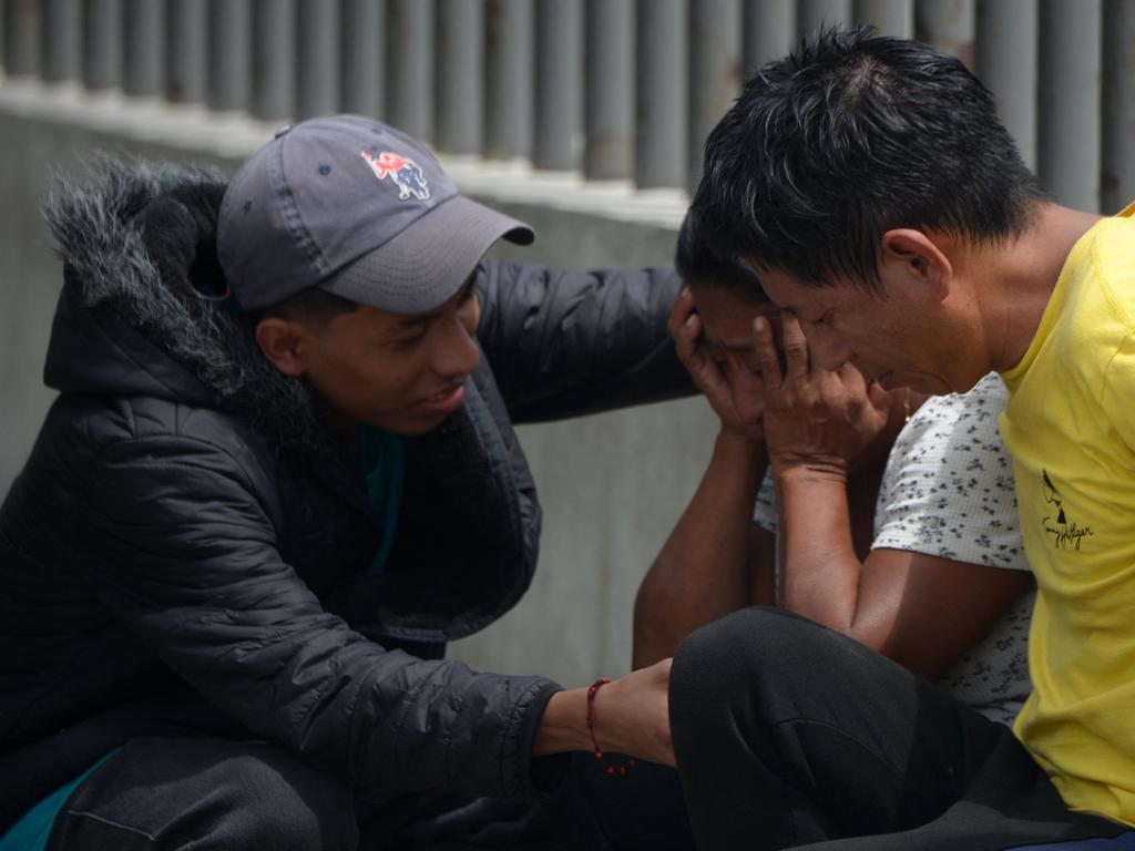 People mourn while waiting for the bodies of their beloved ones following the horrific attack.