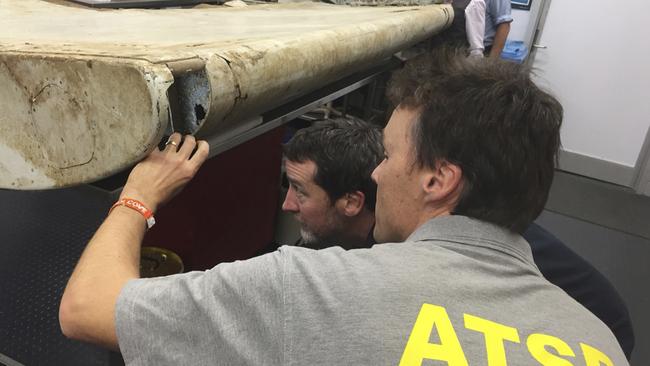 Australian Transport Safety Bureau (ATSB), staff examine a piece of aircraft debris at their laboratory in Canberra, Australia. Picture: via AP.