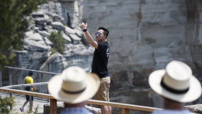 A tourist takes a selfie on the other side of the safety fence. Photo: Tim Pascoe