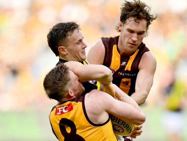 Rhyan Mansell of the Tigers is tackled by Jack Scrimshaw and Sam Frost. Picture: Josh Chadwick/AFL Photos/via Getty Images.