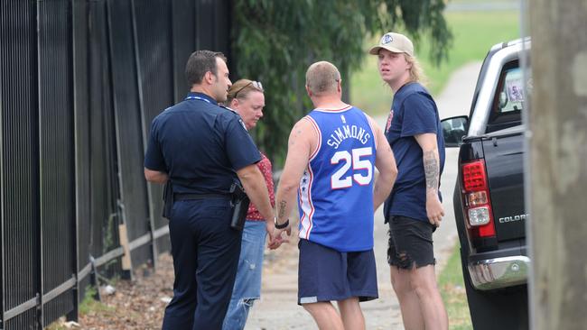 People speak to a police officer at the scene of the three-car smash. Picture: Andrew Henshaw