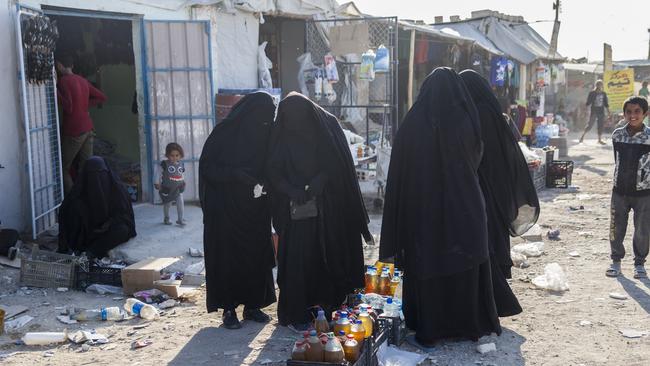 Women buy food in the Al Hawl camp. Picture: AAP.