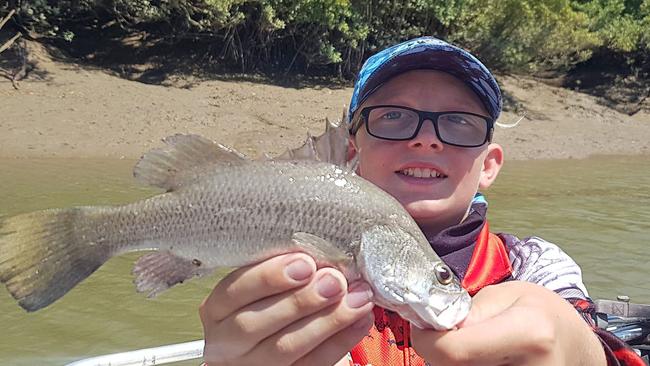 Ryan Higgs with one of Darwin Harbour’s little barra which are as prevalent as ever this year. Picture: Wendy Higgs