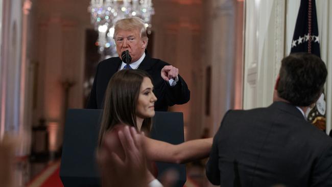 FILE - In this Nov. 7, 2018 file photo, President Donald Trump watches as a White House aide reaches to take away a microphone from CNN journalist Jim Acosta during a news conference in the East Room of the White House in Washington. CNN is suing the Trump administration, demanding that Acostaâ€™s press credentials to cover the White House be returned. The administration revoked them last week following President Trumpâ€™s contentious news conference, where Acosta refused to give up a microphone when the president said he didnâ€™t want to hear anything more from him. (AP Photo/Evan Vucci, File)