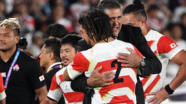 Japan coach Jamie Joseph gives his players a hug after their incredible win.