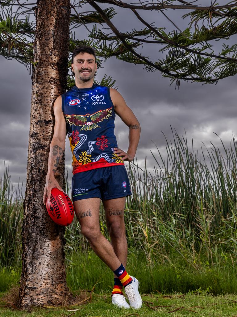 Crows star Izak Rankine, at Goolwa on Ngarrindjeri country, with the club’s 2024 Indigenous guernsey he designed. Picture: Sarah Reed Photography