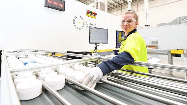 A Chrysos PhotonAssay operator places sample jars on to the input conveyor.