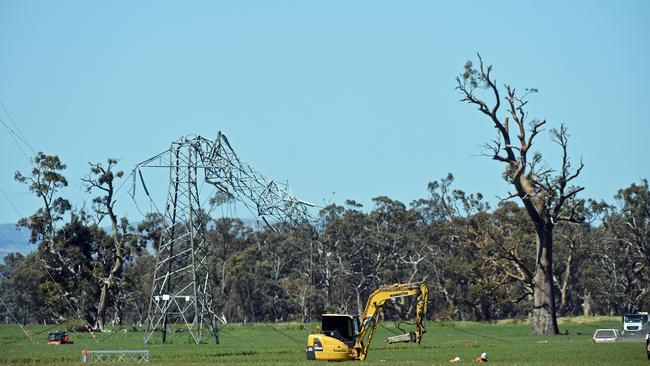 A digger works near a damaged power tower near Melrose in the state’s mid north.