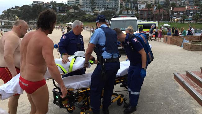 Rescuers and paramedics carry the teen to a stretcher. Picture: Derrick Krusche