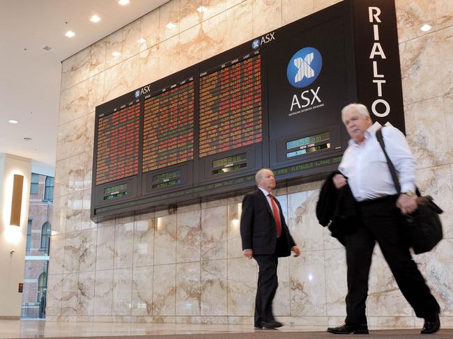 Two men walk past the Australian Securities Exchange (ASX) board showing a sea of red in Melbourne on November 10, 2011, as Australian shares closed down 2.35 percent but off their lows after Italian debt yields spiked to levels judged to be unsustainable in the longer term. The benchmark S&P/ASX200 index dropped 102.0 points to 4,244.1, tracking big falls on global markets, but they recovered slightly from a dive of more than three percent in morning trade. AFP PHOTO / WILLIAM WEST