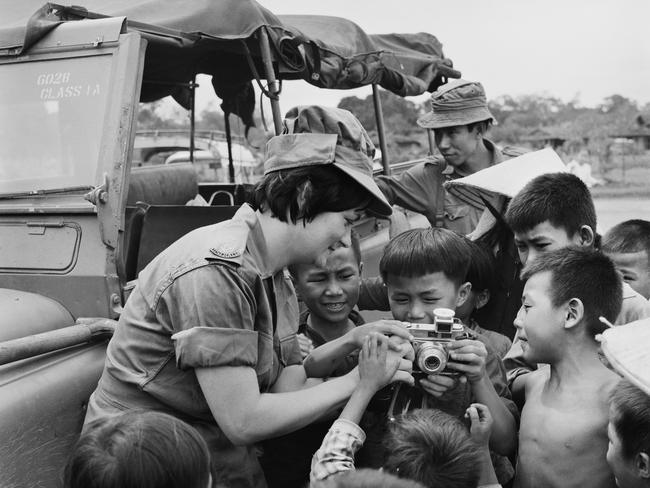 Army Nurse Lieutenant Colleen Mealy of Port Augusta shows the children from the village of Hoa Long how to operate her camera. Picture: Australian War Memorial