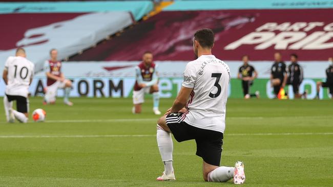 Sheffield United defender Enda Stevens kneels during a minute’s silence prior to his team’s English Premier League match against Aston Villa at Villa Park in Birmingham. Picture: AFP