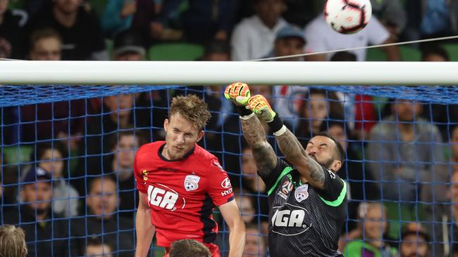 Paul Izzo punches the ball clear of Adelaide United teammate Ben Halloran. (AAP Image/David Crosling)