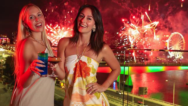 Lucy Evans and Ally West enjoy New Years Eve fireworks from the WET Deck at W Brisbane. Pics Adam Head