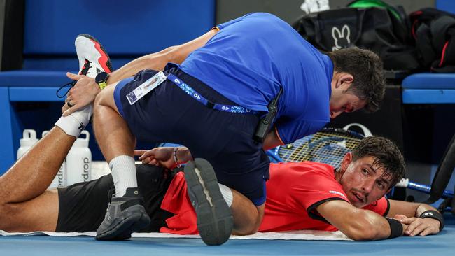 Popyrin just getting some courtside physio done. (Photo by Adrian DENNIS / AFP)