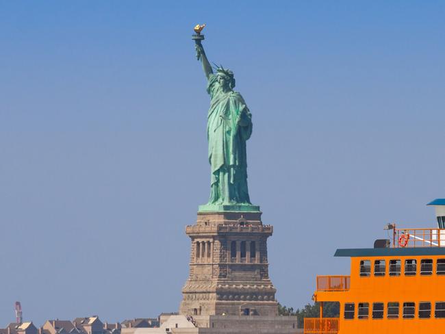 Staten Island Ferry and The Statue of Liberty, lit by morning sun. Commuters on the ferry enjoying beautiful summer morning. Middle part of hte statue is slightly distorted by the hot exhaust from the ferry.  Picture: iStockRob McFarland, new york islands, escape