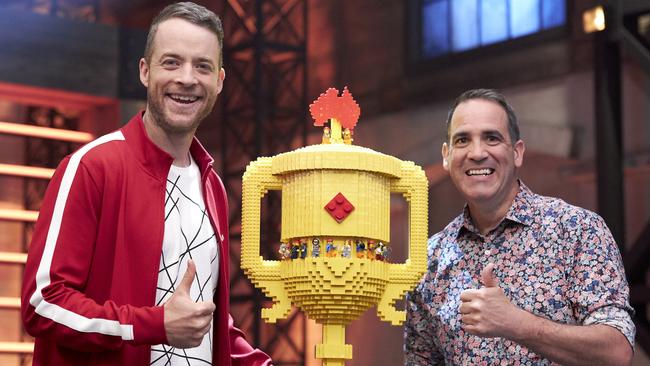 Lego Masters host Hamish Blake and judge Ryan ‘The BrickMan’ McNaught with the show's grand final trophy. Supplied: Channel 9