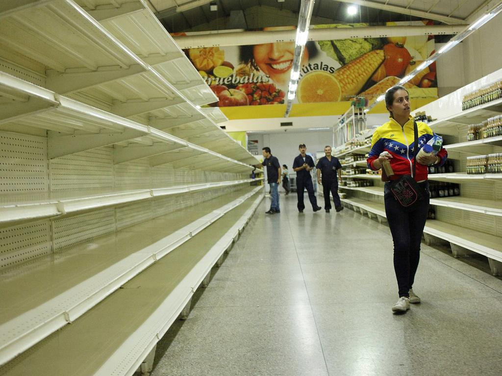 People walk past empty shelves at a supermarket in San Cristobal, Venezuela on January 16, 2018. Picture: REUTERS/Carlos Eduardo Ramirez