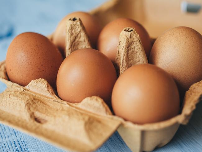 Eggs background. Closeup view of eggs in carton box on wooden table. Food and health concept.  Picture: istock