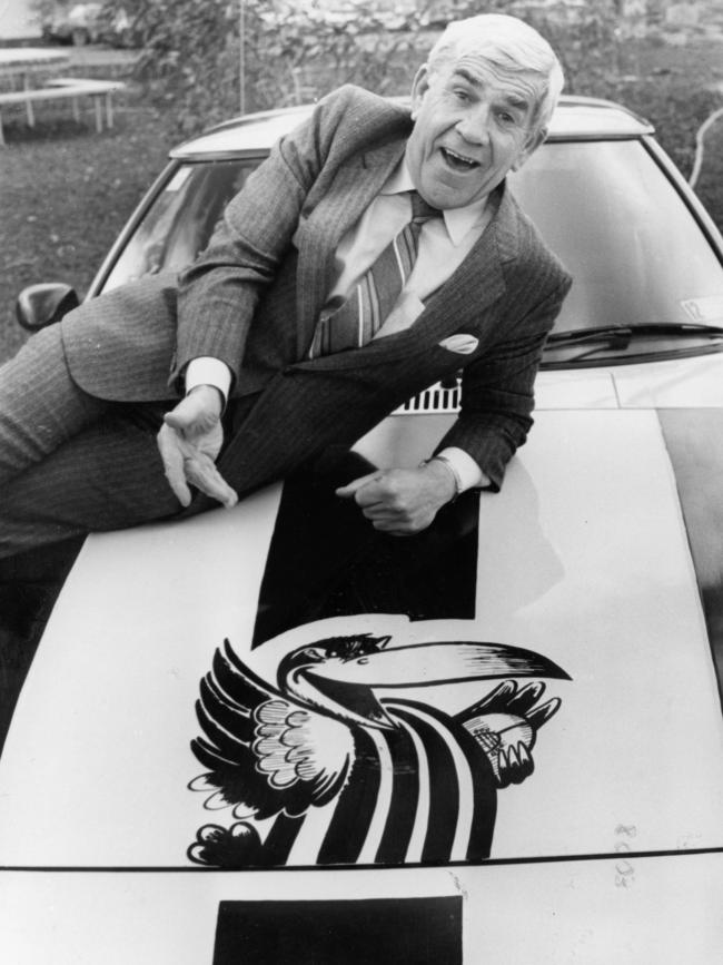 Lou Richards on the bonnet of a car painted with Collingwood magpie logo.