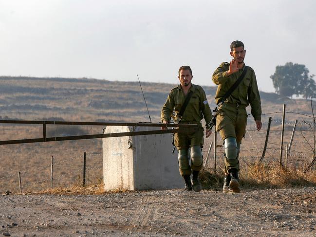 Israeli soldiers man a position on a road leading to the Syrian border, near the location where the army said it killed four men laying explosives at a security fence along the Israeli-occupied sector of the Golan Heights, adjacent to Syrian-controlled territory, amid high tentions between the two rival countries. - Tensions are already high between bitter rivals Israel and Syria. Last month, Israeli army helicopters struck military targets in southern Syria in retaliation for earlier "munitions" fire towards Israel. Israel did not directly blame Syrian forces for the munitions fire, but said it held the Damascus government responsible. (Photo by JALAA MAREY / AFP)