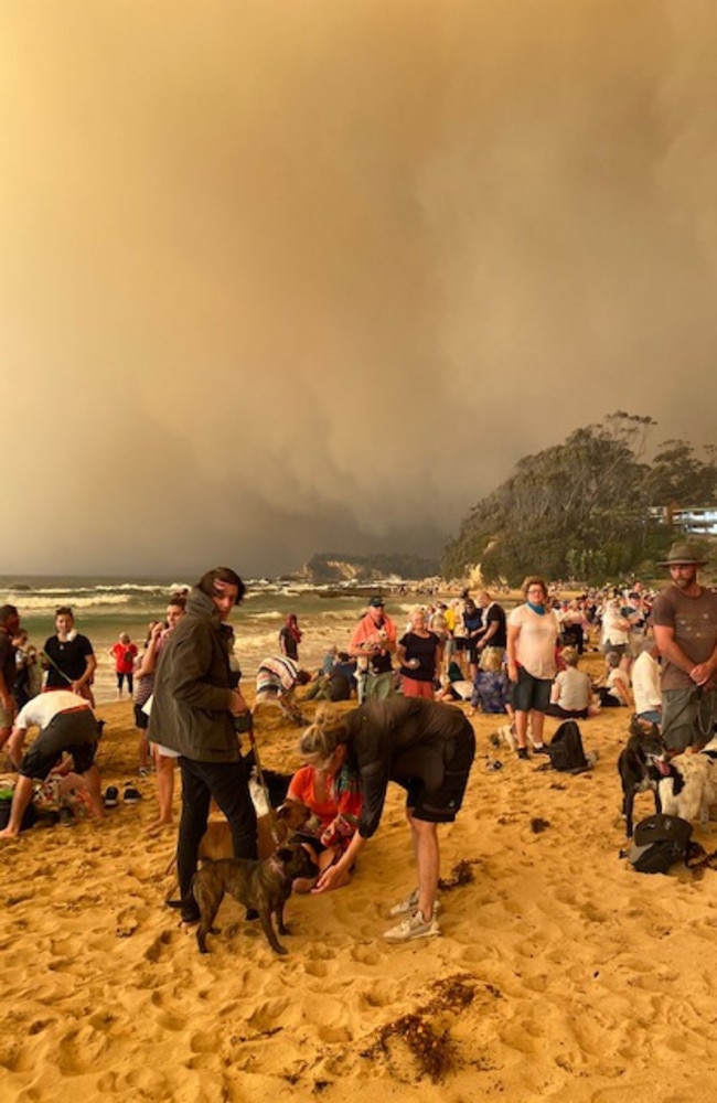 Tourists and locals on the beach at Batemans Bay at the height of the Black Summer bushfires. The NSW south coast was one of the areas most devastated by the fires. Picture: Supplied by NSW Surf Lifesaving