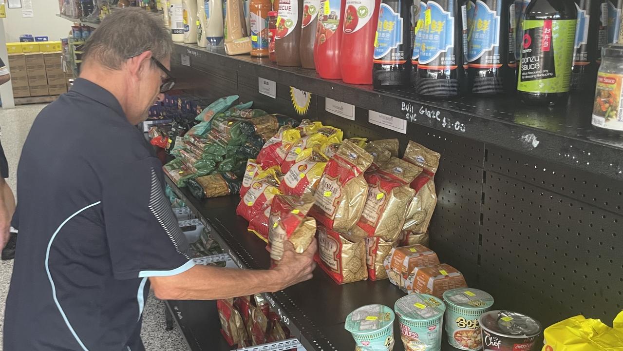 Johnno, one of the many volunteers, stacks the shelves of Maryborough's Food Basket.