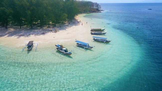 Tourist ships anchored on the Gili Rengit beach at Lombok, Indonesia.