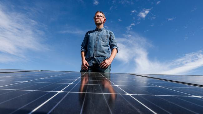 Solar Quotes founder and CEO Finn Peacock on the roof alongside solar panels at NRG Solar. Picture: Kelly Barnes