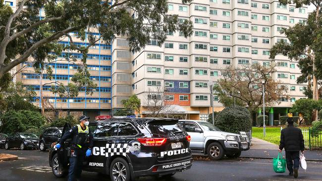 A police officer approaches a resident arriving home with some groceries. Picture: Ian Currie