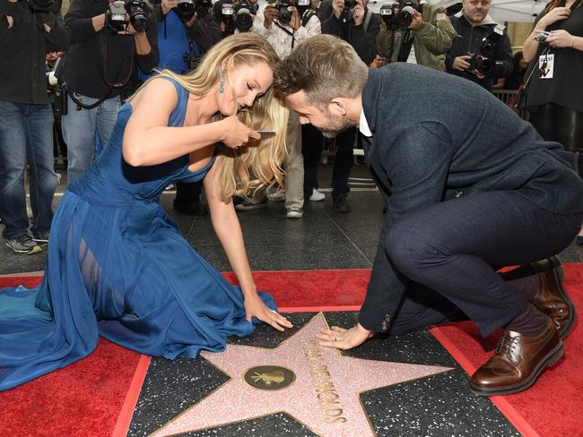 Actor Ryan Reynolds, right, joins his wife, actress Blake Lively, as she photographs his new star on the Hollywood Walk of Fame. Picture: AP