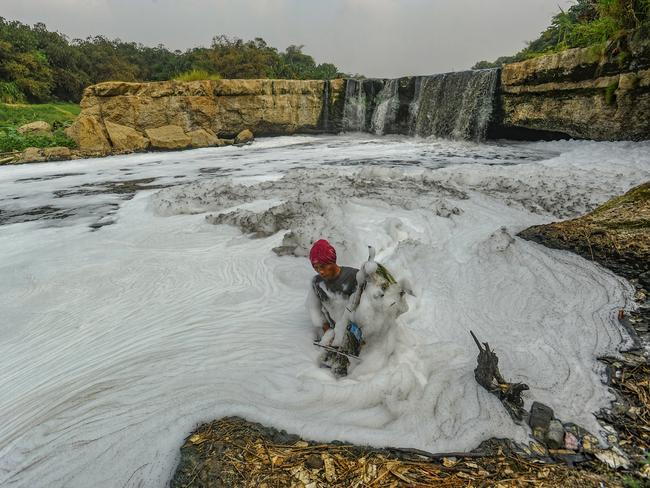 A resident fishes on the Cileungsi River in Indonesia, now marred by thick foam from industrial waste run-off. The pollution, intensified by a dry season, threatens local health and underscores the urgent need for stronger environmental protections. Picture: Arie Basuki