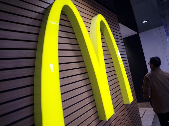 FILE - In this Dec. 17, 2014 file photo, a man walks by a McDonald's logo in front of its restaurant in Tokyo. McDonald’s is set to unveil its latest plans to revive its sputtering business on Monday, May 4, 2015. (AP Photo/Eugene Hoshiko, File)