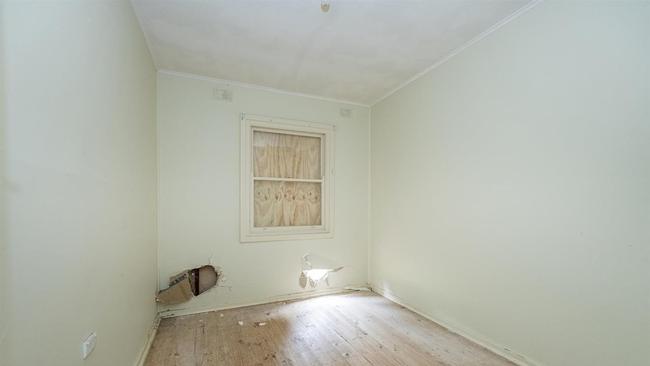 The property had holes in the wall and the windows boarded up. Picture: realestate.com.au