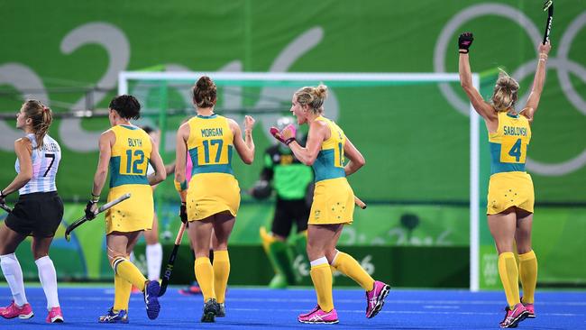 Australia's Madonna Blyth (2L), Georgina Morgan (C), Gabi Nance (2R), and Casey Sablowski (R) celebrate after their goalie stopped a penalty shot, as Argentina's Martina Cavallero looks on during the women's field hockey Australia vs. Argentina match of the Rio 2016 Olympic Games at the Olympic Hockey Centre in Rio de Janeiro on August, 11 2016. / AFP PHOTO / MANAN VATSYAYANA